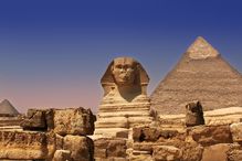 Pyramid and Sphinx in Egypt under a blue sky.