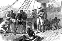 Enslaved people being chained by enslavers aboard a ship and forced below deck