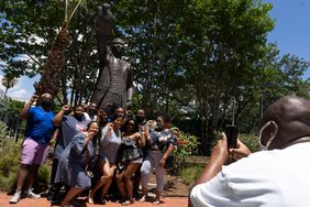 People pose in front of the statue of former Texas Representative Al Edwards