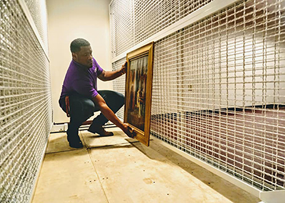 Museum staff mounts artwork on new racking.