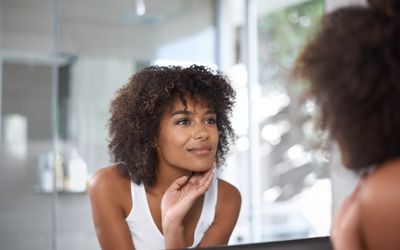 black woman looking in mirror