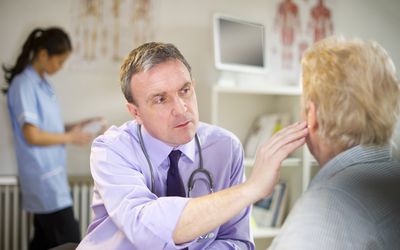 A male doctor examining a woman's ear