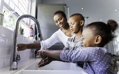 A mom teaching her kids how to wash their hands