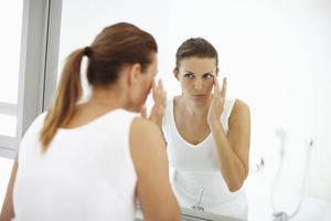 woman looking at herself in mirror