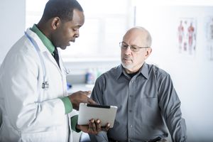 A doctor discusses a new diagnosis with an older male patient.