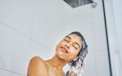 A young woman washing her hair in the shower