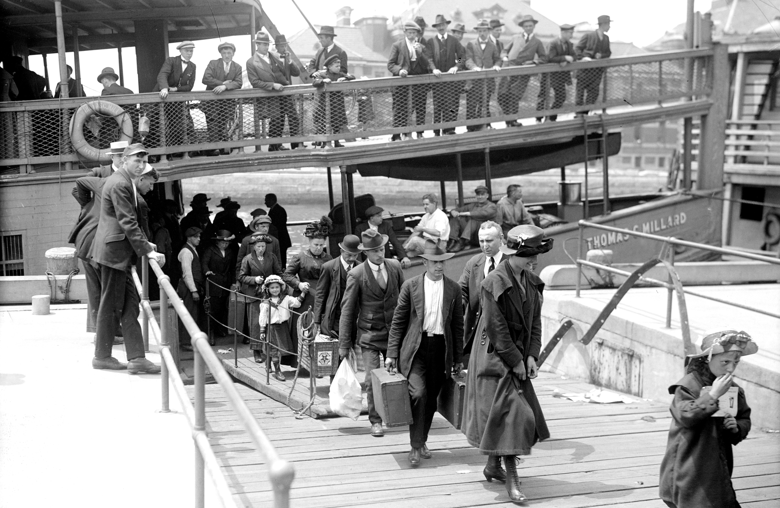 Newly arrived immigrants disembark from the passenger steamer Thomas C. Millard upon their arrival at Ellis Island, in New York, early twentieth century.