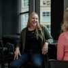 Two woman engage in a conversation with each other in an Amazon office. 