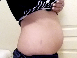 woman who is 6 weeks pregnant, showing her belly