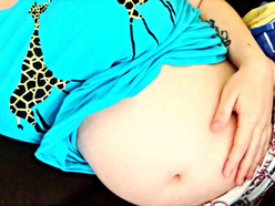 woman 23 weeks pregnant showing her belly