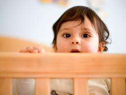 Toddler looking over cot