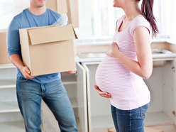 Man with a moving box beside a pregnant woman