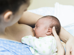 woman breastfeeding newborn baby