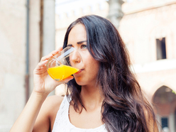 woman drinking glass of orange juice