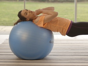 woman exercising by leaning on exercise ball