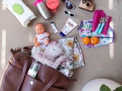 brown bag lying on the floor surrounded by nappy bag essentials