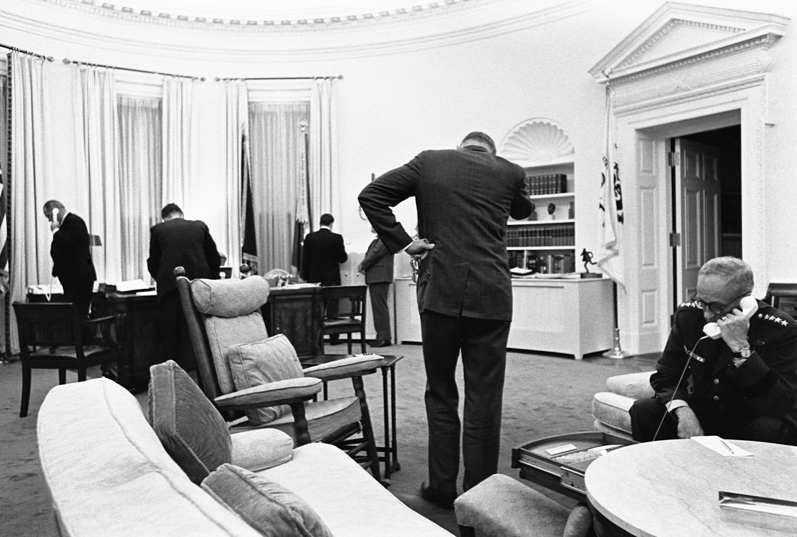 President Lyndon B. Johnson and his advisers gather in the Oval Office to communicate with Federal troops sent in to quell race riots in Detroit, and to plan their handling of the crisis. 1967.