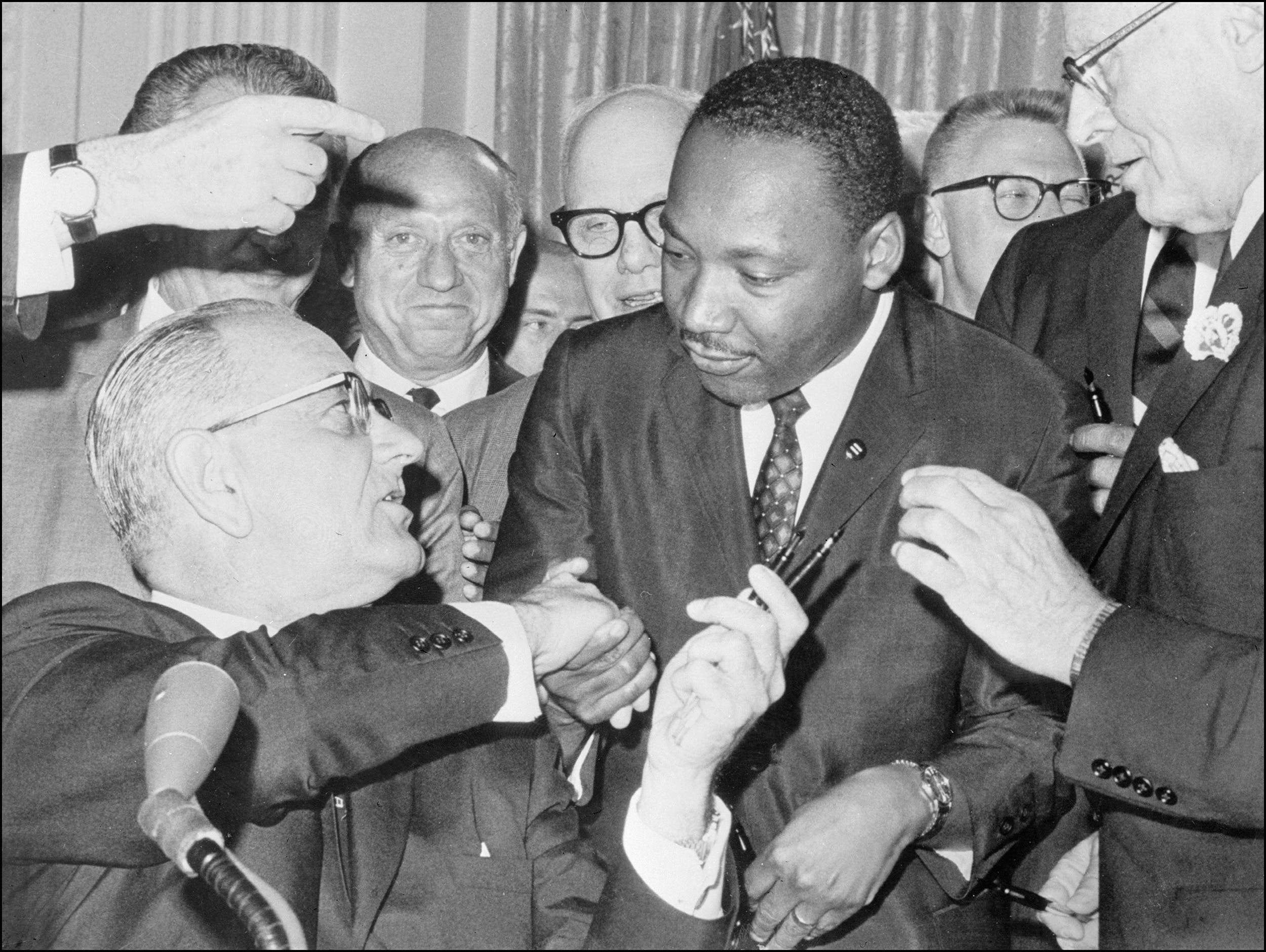 Martin Luther King Jr. shakes hands with President Lyndon B. Johnson at the signing of the 1964 Civil Rights Act.