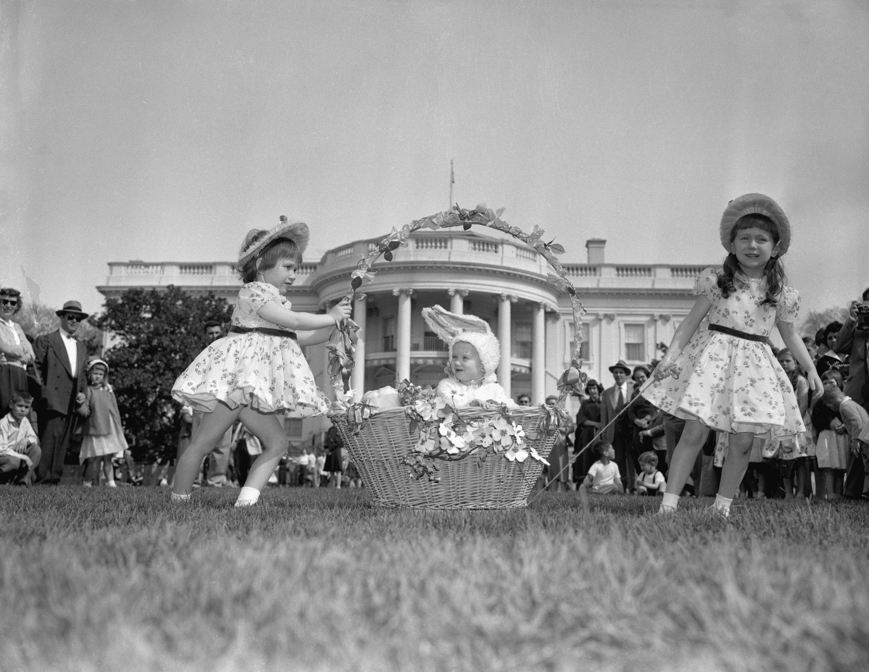 Three sisters at the Traditional Easter Egg Roll on the White House lawn. President Eisenhower hosted the event, which first started in 1878.