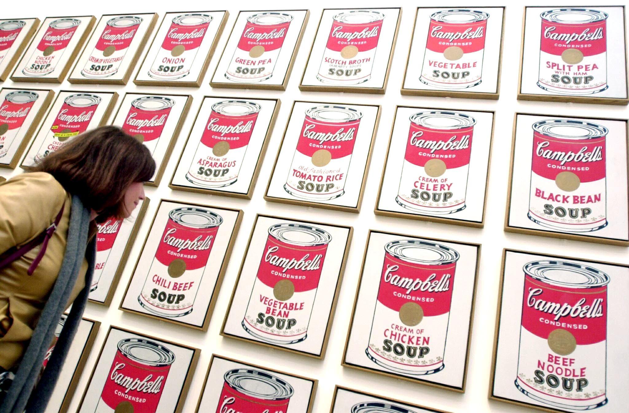 A visitor looks at enigmatic American artist Andy Warhol's "Campbell's Soup Cans" at the Tate Modern in London 05 February 2002. A major retrospective of the controversial Warhol's work is expected to be a highlight of the English capital's cultural year. AFP PHOTO/Nicolas ASFOURI / AFP / NICOLAS ASFOURI (Photo credit should read NICOLAS ASFOURI/AFP via Getty Images)