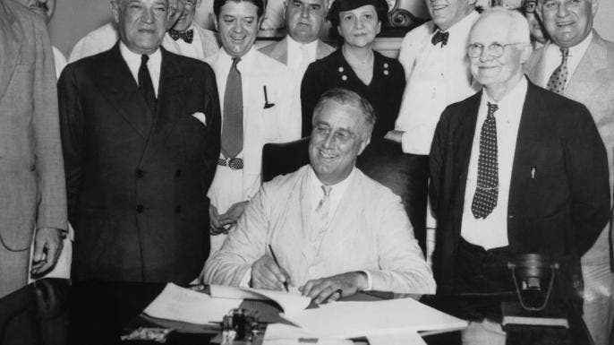 President Franklin D. Roosevelt signs the Social Security Act on 14th August 1935. From left to right, Robert Lee Doughton, chairman of the House Ways and Means Committee, Edwin E. Witte, Director of the President's Social Security Committee, with Senator Robert F. Wagner, co-author of the bill behind him, Senator Robert La Follette, Senator Augustine Lonergan, Labor Secretary Frances Perkins, Senator William H. King, Rep. David John Lewis, co-author of the bill and Senator Joseph F. Guffey.