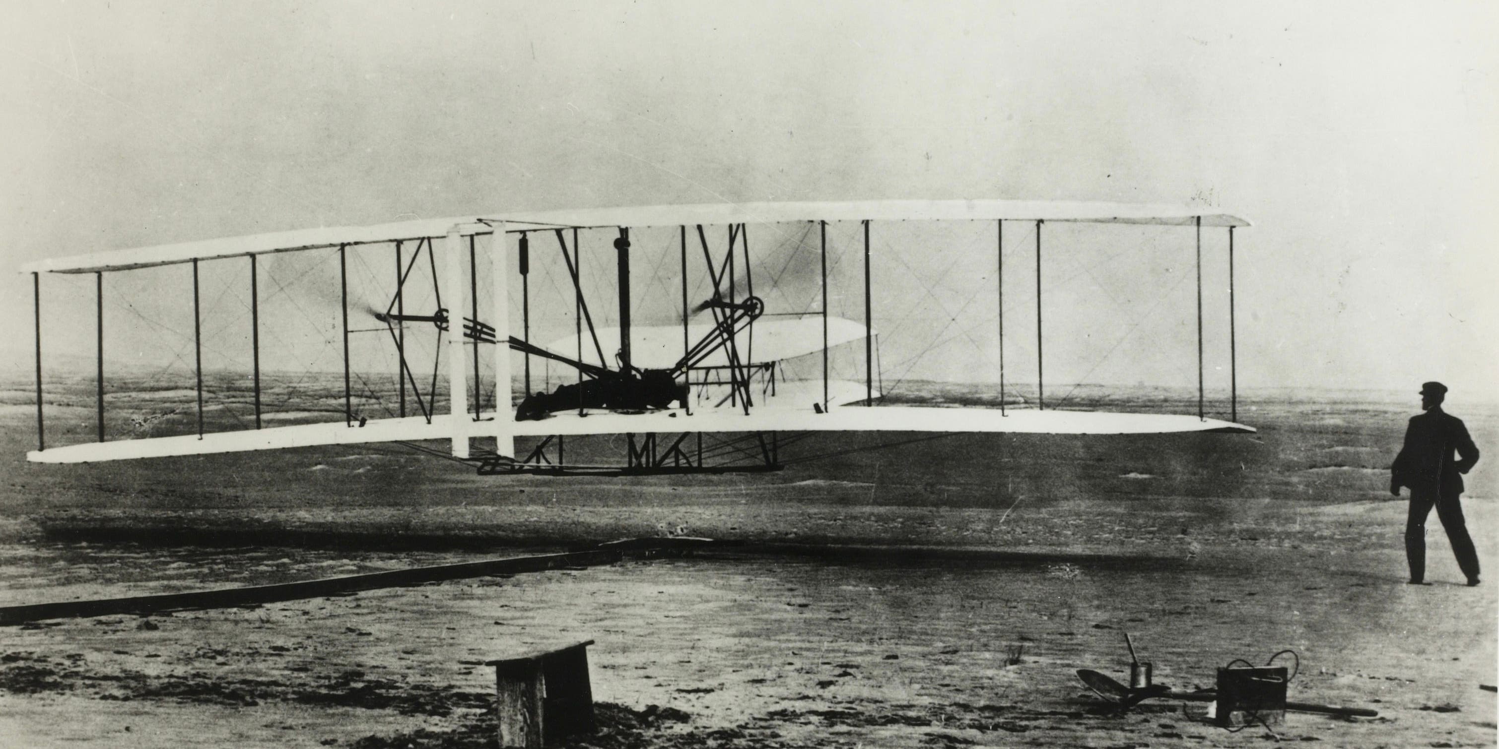 December 17th, 1903, Kittyhawk, North Carolina: The World's first flight with Orville Wright at the controls. His brother Wilbur is running at the side of the machine.