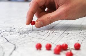 A pin being placed into a map.