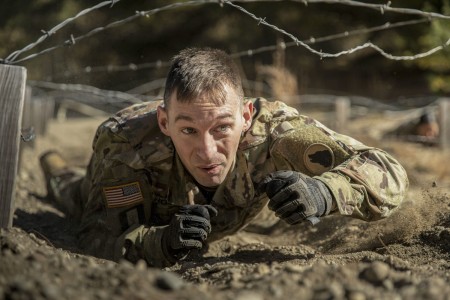 Army Staff Sgt. Corey Rogers low-crawls under barbed wire during the Wolf Cup Competition at Devens Reserve Forces Training Area, Mass., Oct. 14, 2023. The competition tested competencies in basic Army warrior tasks.