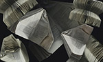 Fotografia sobreposta de vários livros com as páginas dobradas em formato de avião sobre um fundo infinito preto.