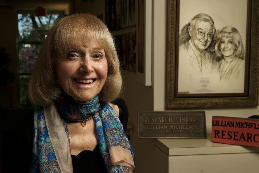WOODLAND HILLS, CA-APRIL 12, 2017: Lillian Michelson, a retired film researcher, is photographed next to an artist's rendering of her and late husband Harold Michelson, a storyboard artist/production designer, on the wall in front of her apartment in Woodland Hills on April 12, 2017. Lillian and Harold Michelson are featured in a new documentary, Harold and Lillian: A Love Story, directed by Daniel Raim. (Mel Melcon/Los Angeles Times)