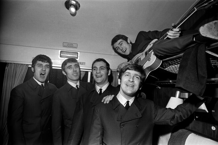 English rock band The Moody Blues pose for a photograph in a first class carriage on a train, 11th November 1964. Left to right : Ray Thomas, Clint Warwick, Mike Pinder, Graeme Edge, and Denny Laine (on shelf). (Photo by Robert Stiggins/Daily Express/Hulton Archive/Getty Images)