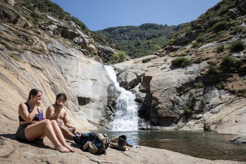 Julian, California - May 24: Brianna Belleville, 22, left, and Armando Versaggi, 25, snack after completing a four mile hike on the Cha'chaany Hamuk Trailhead, formerly known as the Three Sisters Falls Trailhead on Friday, May 24, 2024 in Julian, California. The popular hike has undergone changes including a new parking lot and picnic benches. (Ana Ramirez / The San Diego Union-Tribune)