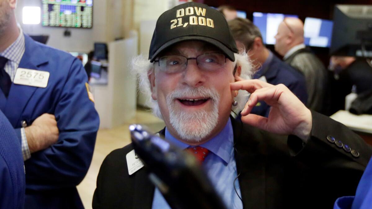 Trader Peter Tuchman wears a "Dow 21,000" hat as he works Wednesday on the floor of the New York Stock Exchange.