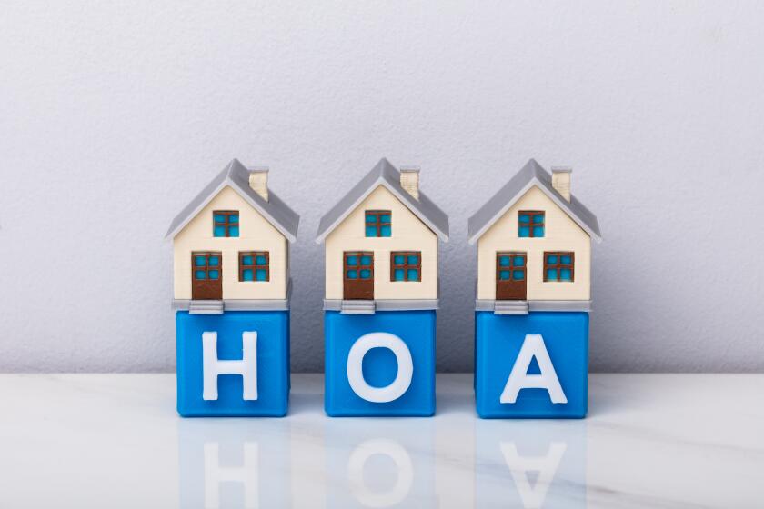 Row of house models on blue HOA cubic blocks .