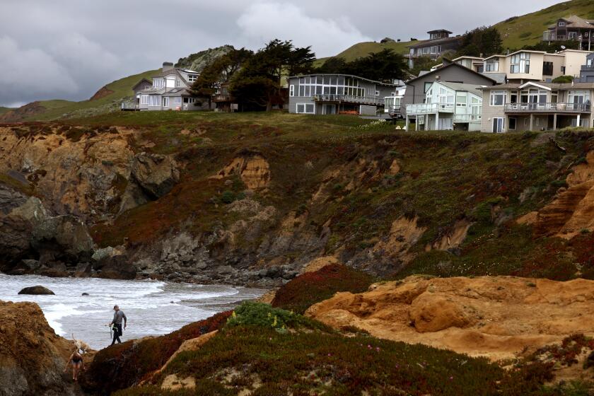DILLON BEACH, CA - APRIL 24, 2024 - Visitors walk along a trail below homes in Dillon Beach on April 24, 2024. Dillon Beach has allowed more rentals than other area in West Marin County. West Marin County, home to some of California's most beautiful beaches and most expensive homes, is putting a cap on short-term rentals. Proponents of the cap say Airbnbs have ruined small towns, eating valuable housing stock and making it devoid of actual locals. Opponents say it's so expensive anyway that a vacation rental ban doesn't add affordable housing. This had to go before the California Coastal Commission who proposed regulations would maintain visitor access to the coast while preventing the further erosion of West Marin's year-round supply of rental housing. (Genaro Molina/Los Angeles Times)