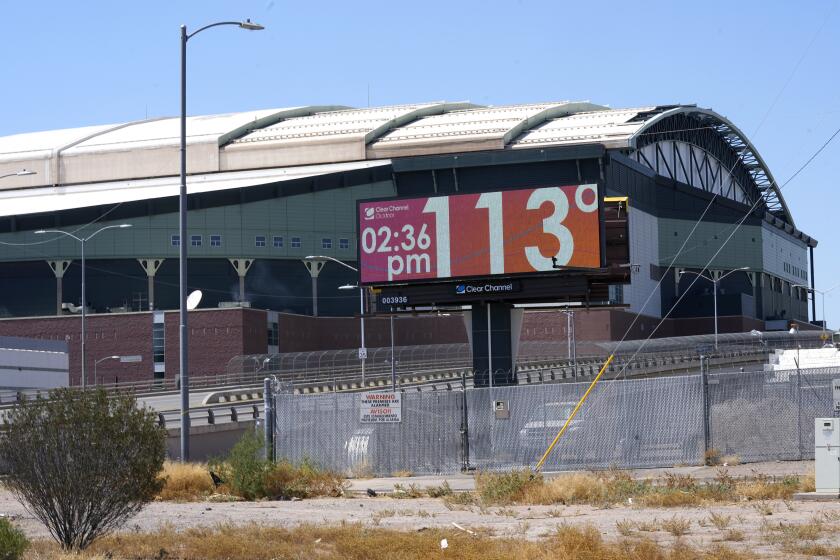FILE - With Chase Field, home of the Arizona Diamondbacks baseball team in the background, a digital billboard updates the time and temperature as temperatures are expected to hit 116-degrees July 18, 2023, in Phoenix. President Joe Biden plans to announce new steps to address the extreme heat that has threatened millions of Americans, most recently in the Southwest. (AP Photo/Ross D. Franklin, File)