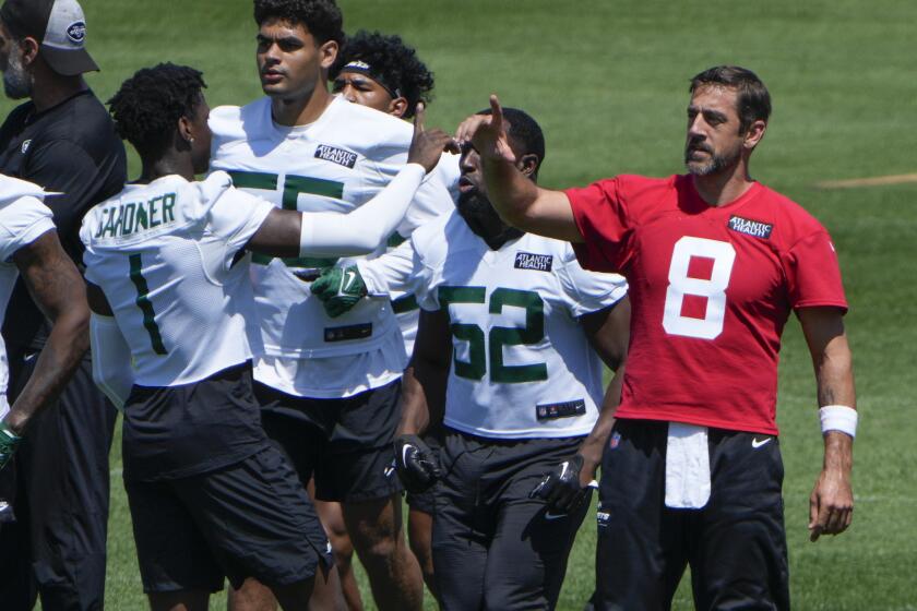 New York Jets quarterback Aaron Rodgers (8), right, greets Sauce Gardner (1) during a practice at the NFL football team's training facility in Florham Park, N.J., Tuesday, May 21, 2024. (AP Photo/Seth Wenig)