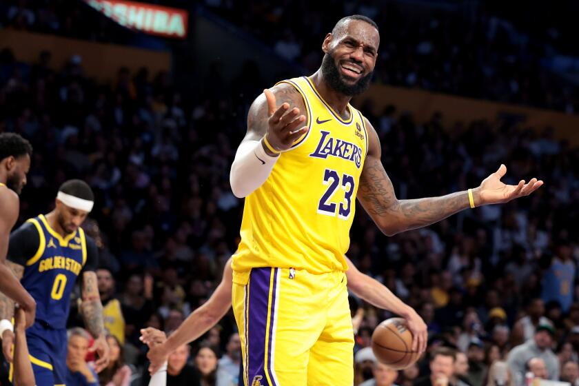 The Lakers' LeBron James raises his arms and disputes a call during a loss to the Warriors Tuesday