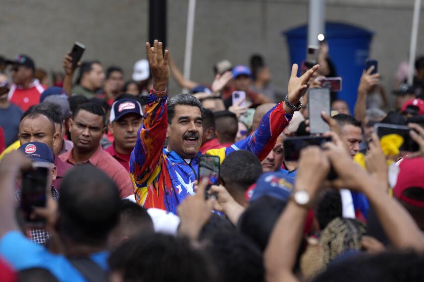 FILE - Venezuelan President Nicolas Maduro greets young supporters marching against U.S. sanctions, in Caracas, Venezuela, May 17, 2024. As Maduro seeks a third term, he has slowly transformed into a defender for migrants, challenging news reports linking some to criminal activities and accusing immigration authorities in other countries of abusing Venezuelans. (AP Photo/Ariana Cubillos, File)