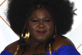 Gabourey Sidibe poses in a bright blue off-the-shoulder dress