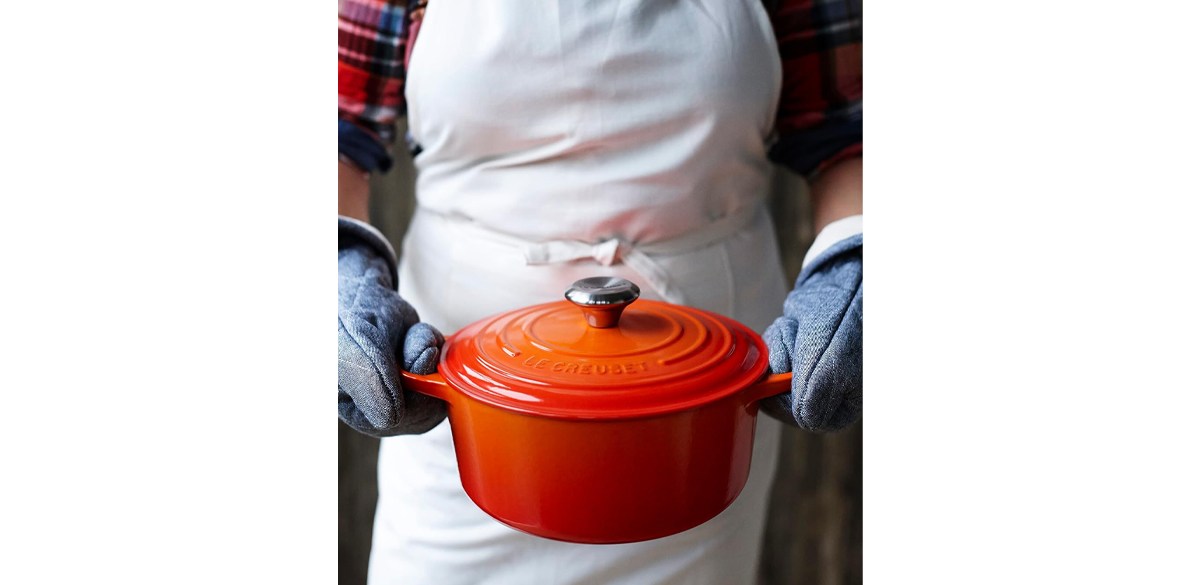 Person holding Le Creuset Enameled Cast Iron Signature Round Dutch Oven