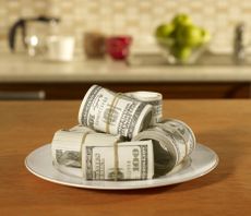 rolls of dollar bills on a dinner plate
