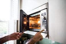 Image of someone opening a microwave. 