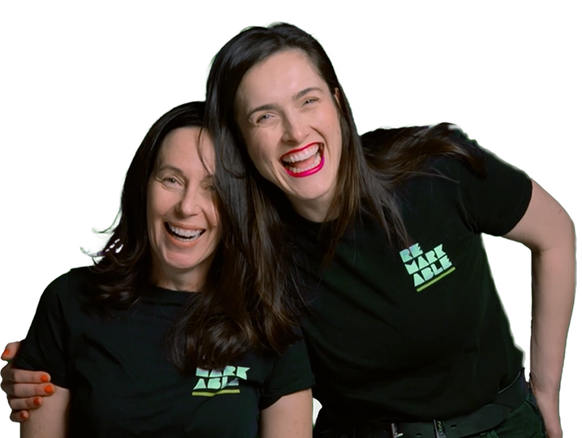 Two people with joyful expressions wearing matching black t-shirts with a Remarkable logo.