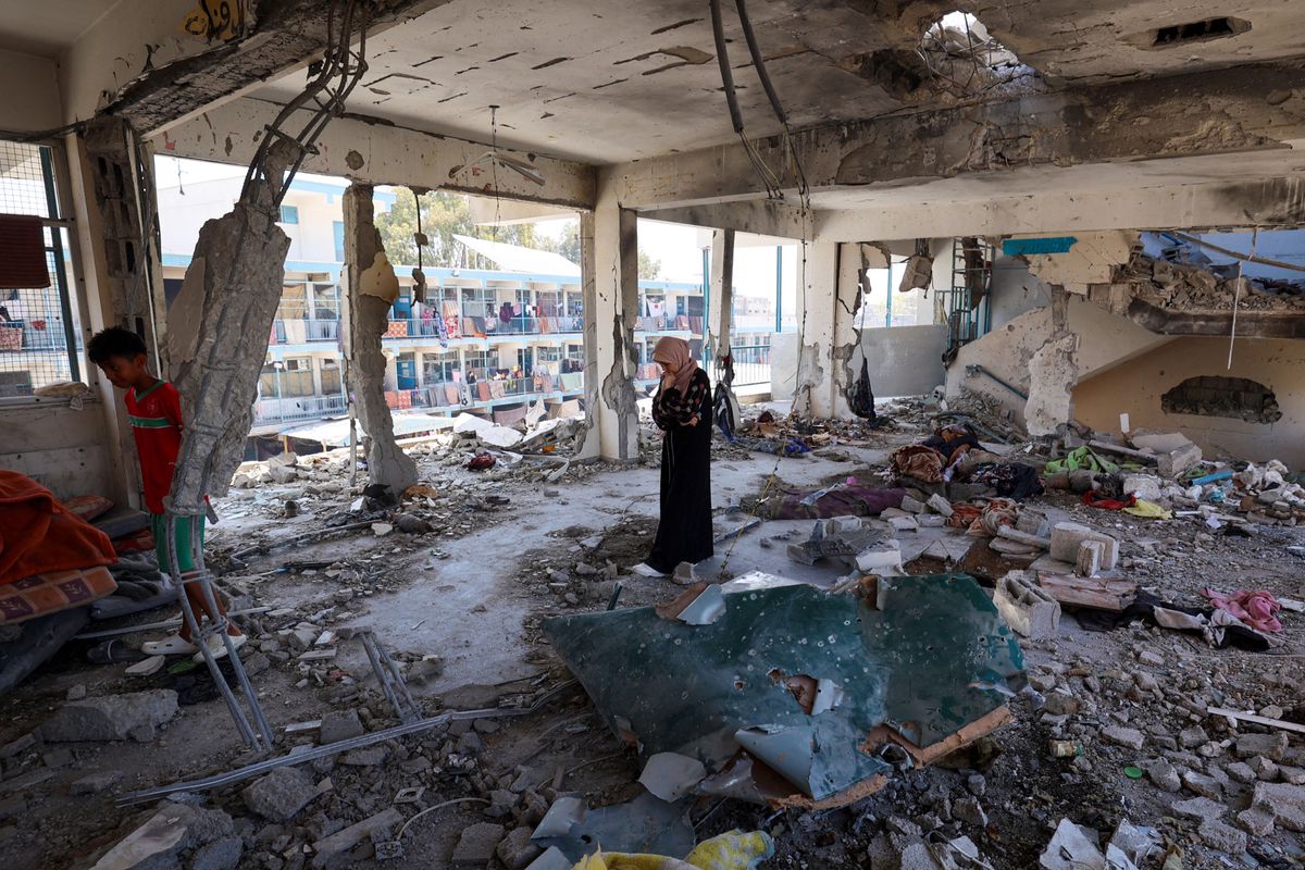 Une femme palestinienne regarde les débris de l'école détruite par une frappe israélienne