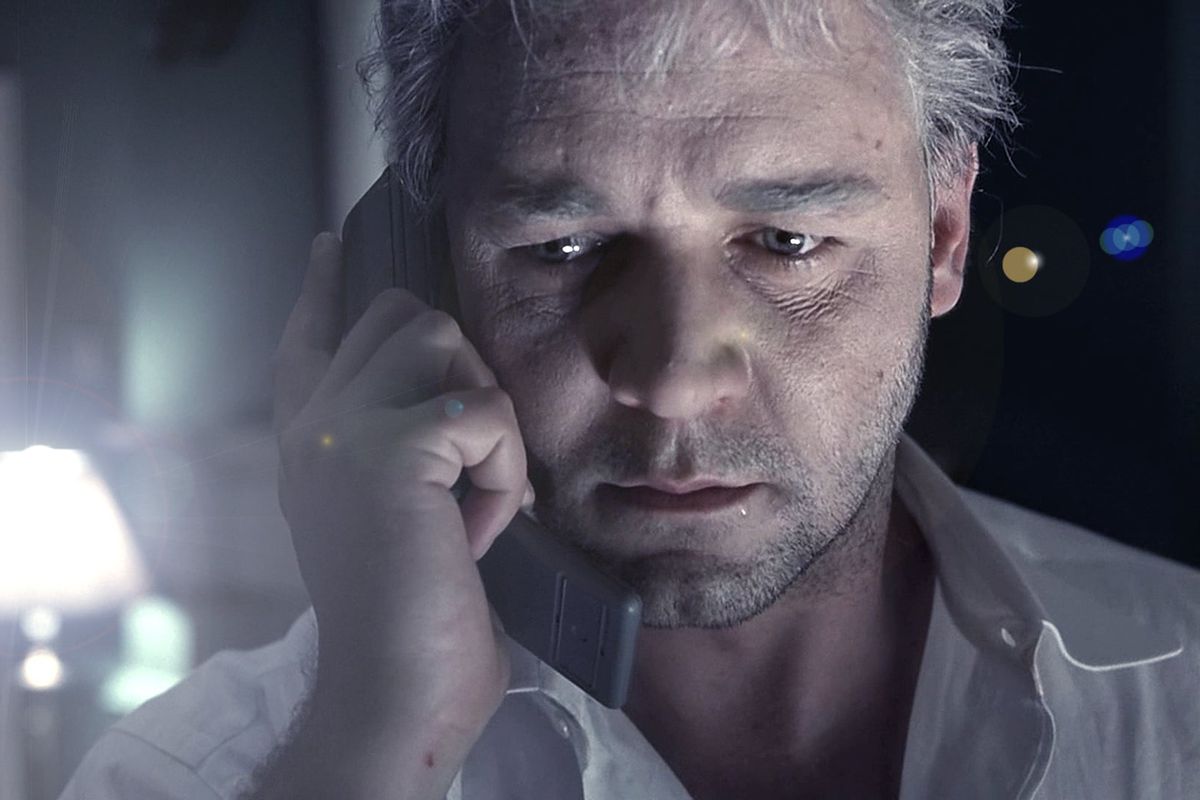 Russell Crowe in The Insider holding a phone