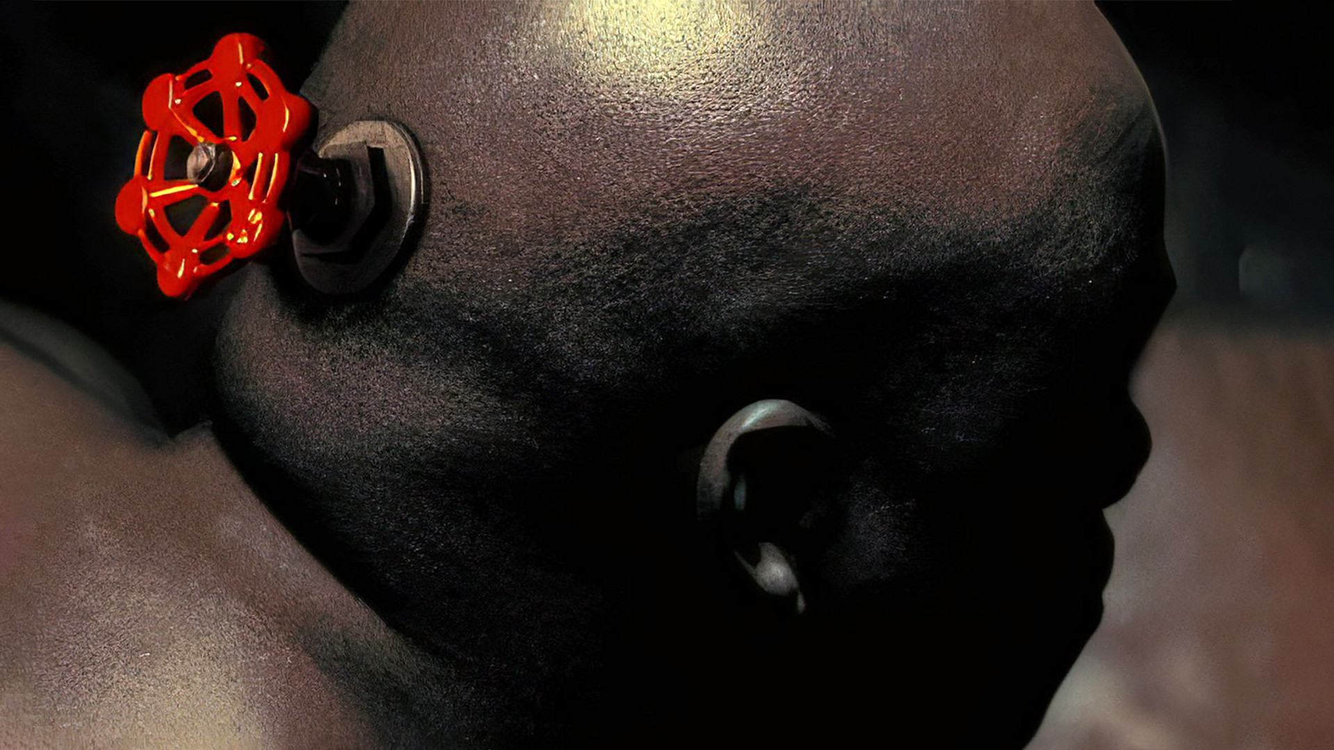 A photo of a bald man with a spigot valve attached to his head, an image used in Valve’s logo loading screens