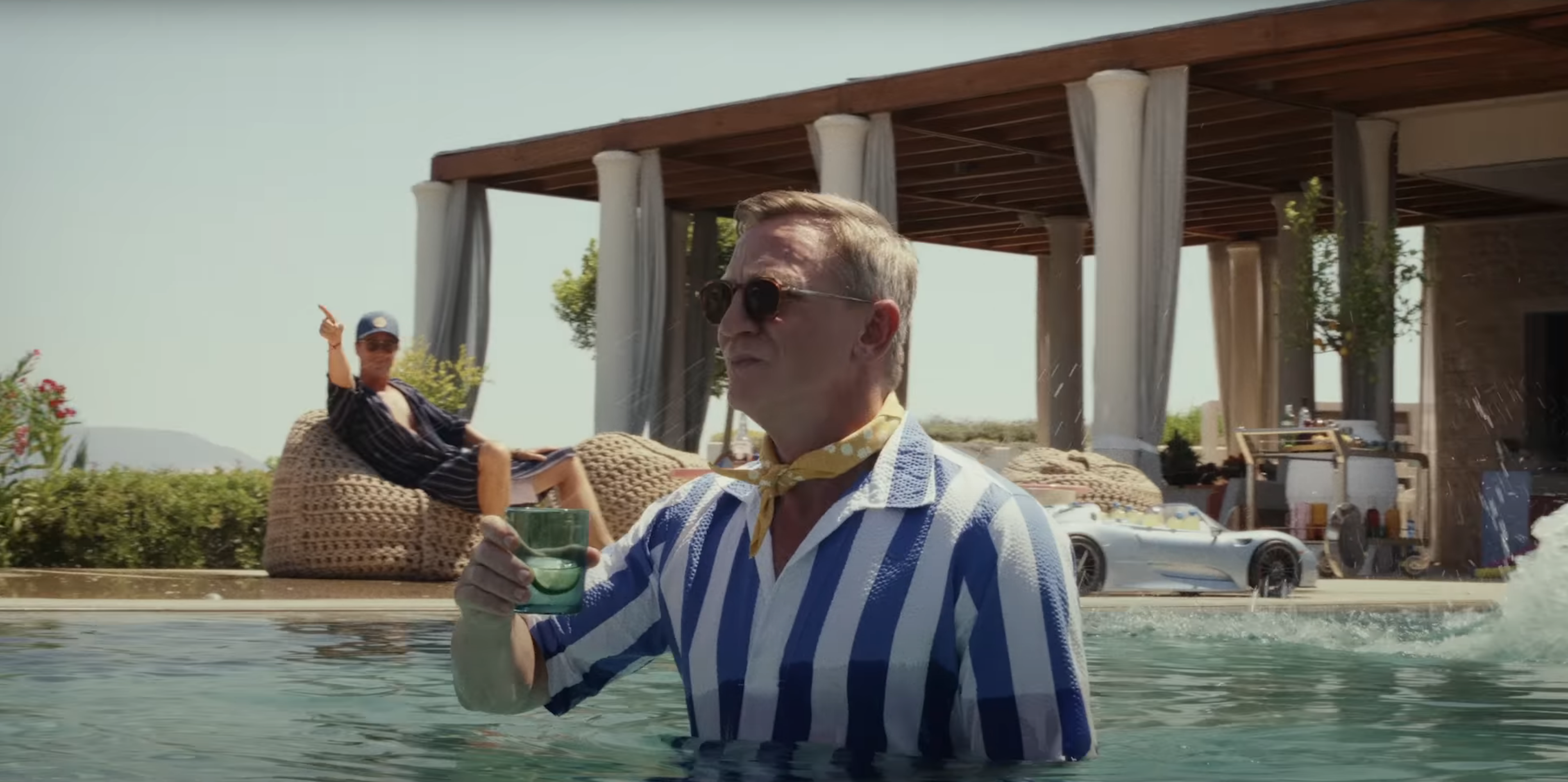 Daniel Craig as Benoit Blanc standing in a pool holding a drink in Glass Onion: A Knives Out Mystery