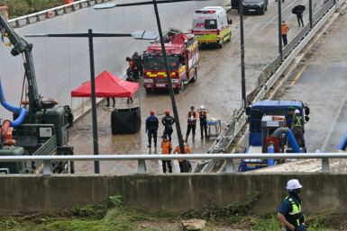 폭우로 약 15대의 차량이 갇힌 지하도 침수로 이어지는 도로를 따라 한국 구조대원들이 보인다.