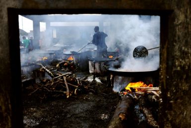 Cooks work over open fires in Kivukoni fish market in Dar es Salaam, Tanzania